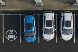 Prospettiva dall'alto di un parcheggio attrezzato con colonnine di ricarica elettrica.