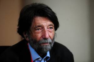 primo piano del filosofo Massimo Cacciari con una abito scuro e una camicia azzurra