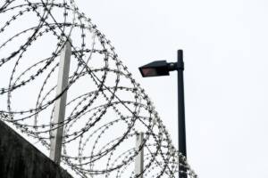 Filo spinato a spirale installato sulla sommità del muro di cinta di un carcere.