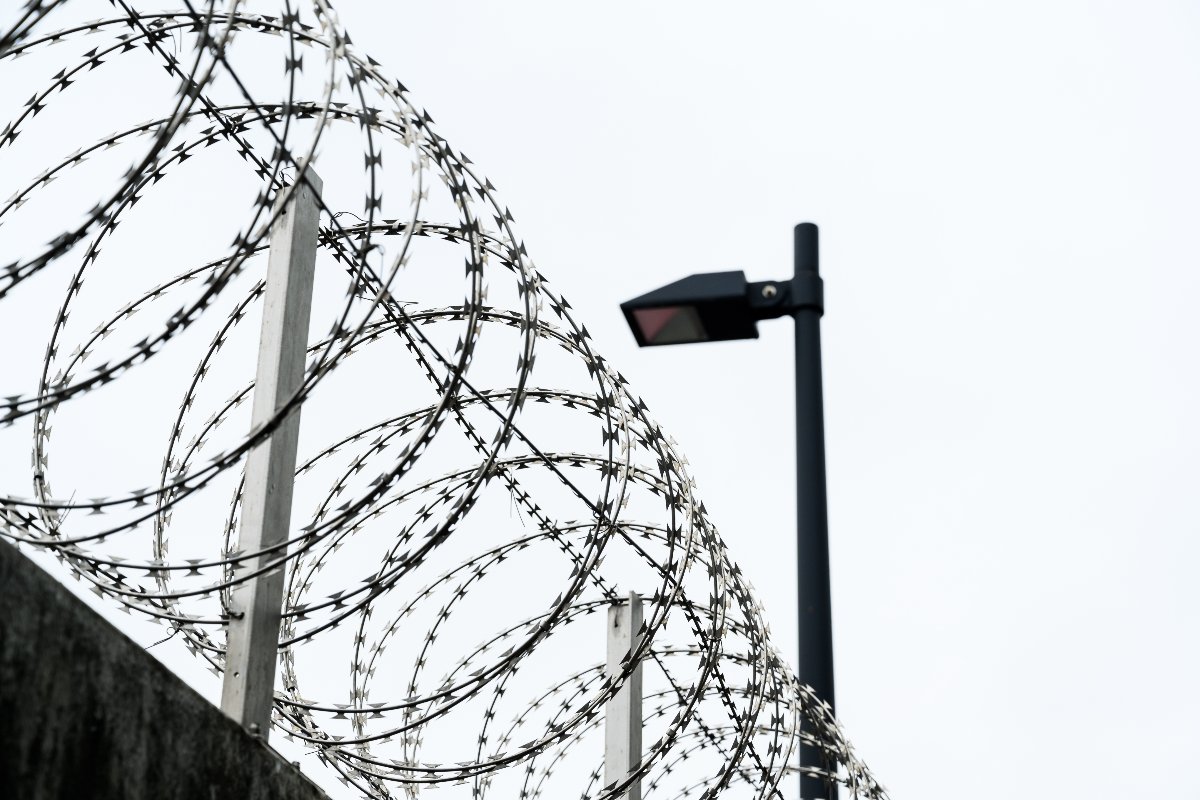 Filo spinato a spirale installato sulla sommità del muro di cinta di un carcere.
