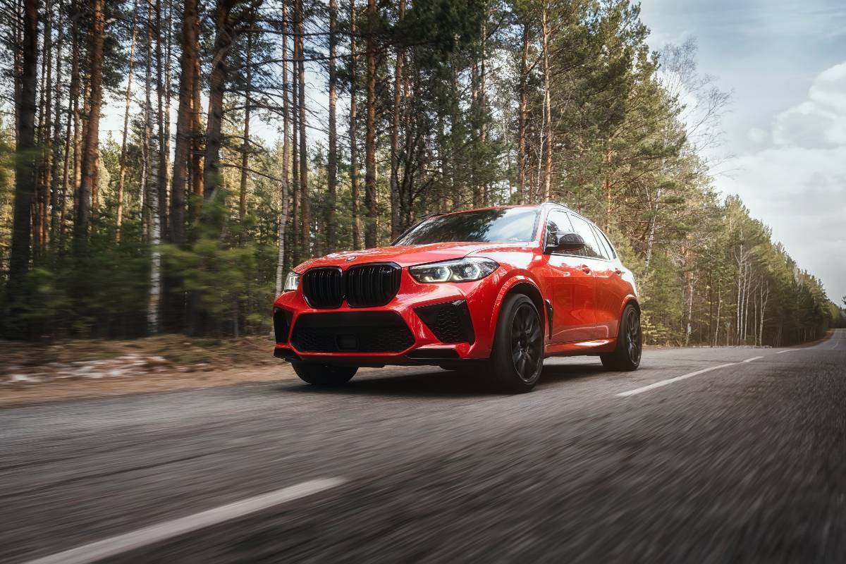La BMW rossa che sfreccia veloce lungo la strada.