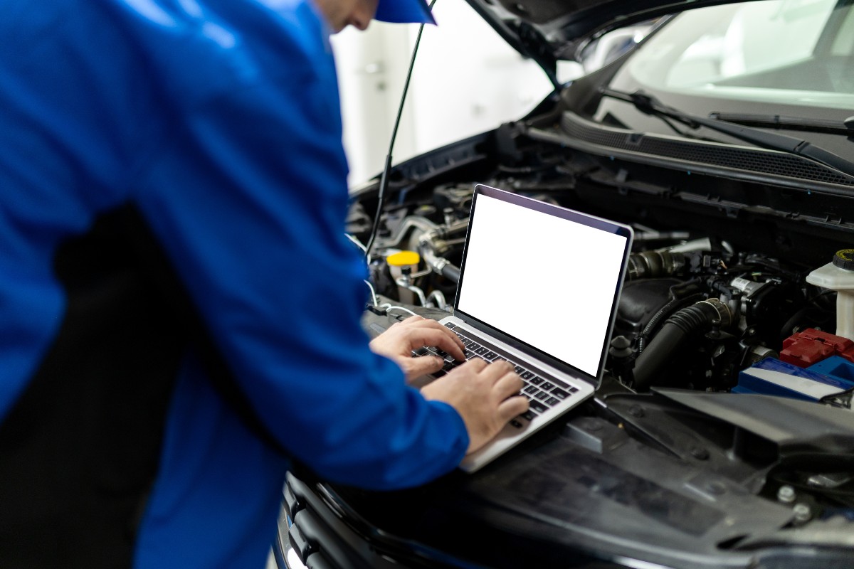 Un meccanico che esegue la diagnostica elettronica di un'auto.