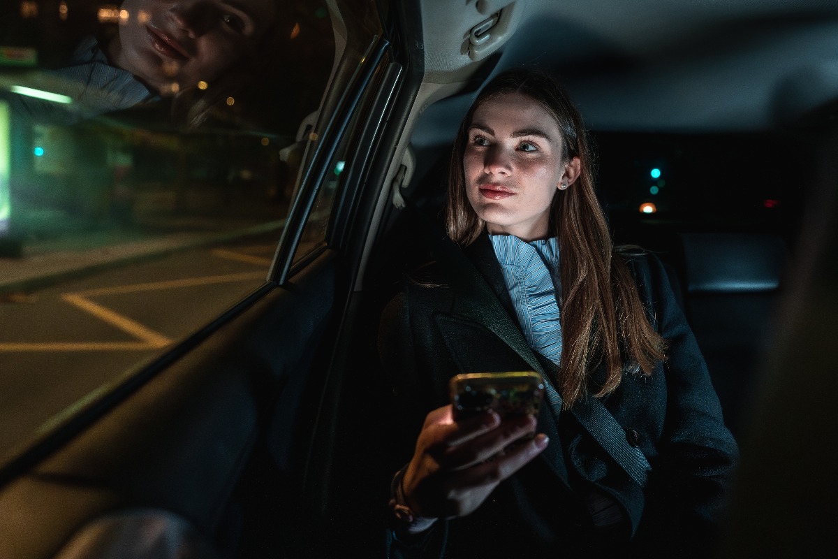 Una donna d'affari sul sedile posteriore di un auto.