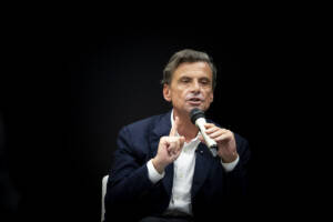 Carlo Calenda parla con il microfono ad un evento in Belgio