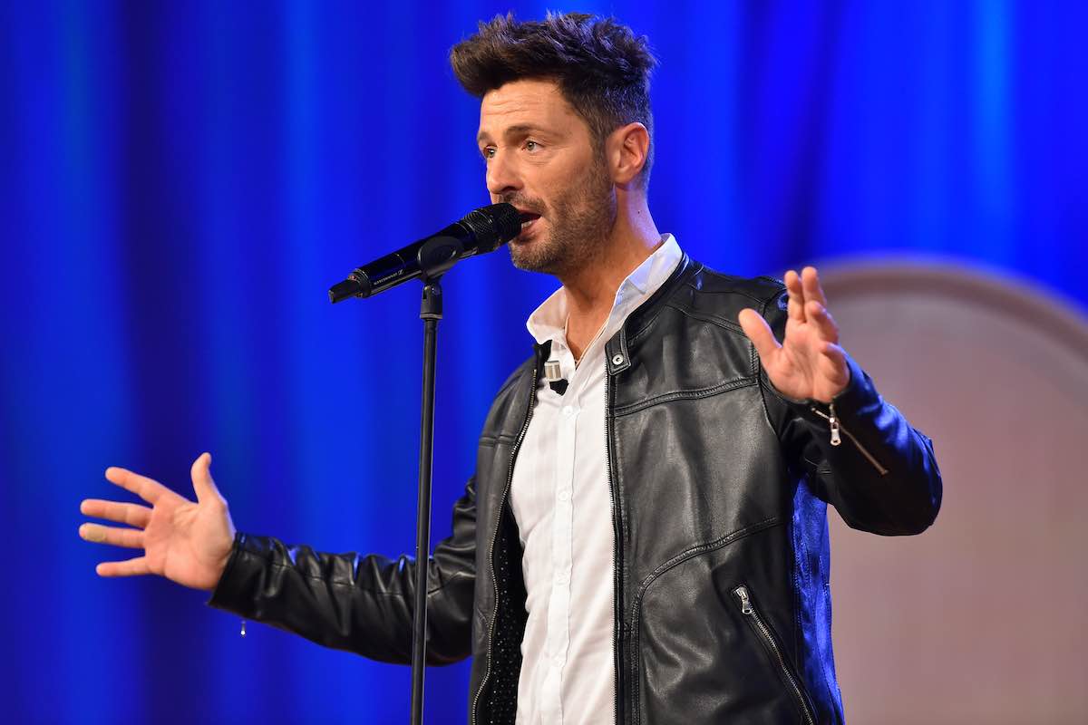 Filippo Bisciglia al Maurizio Costanzo Show parla con un microfono