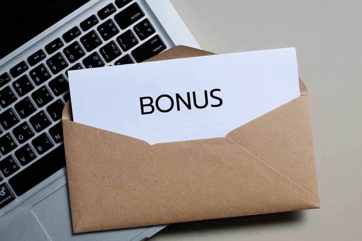una busta con una scritto bonus sopra una tastiera di un pc