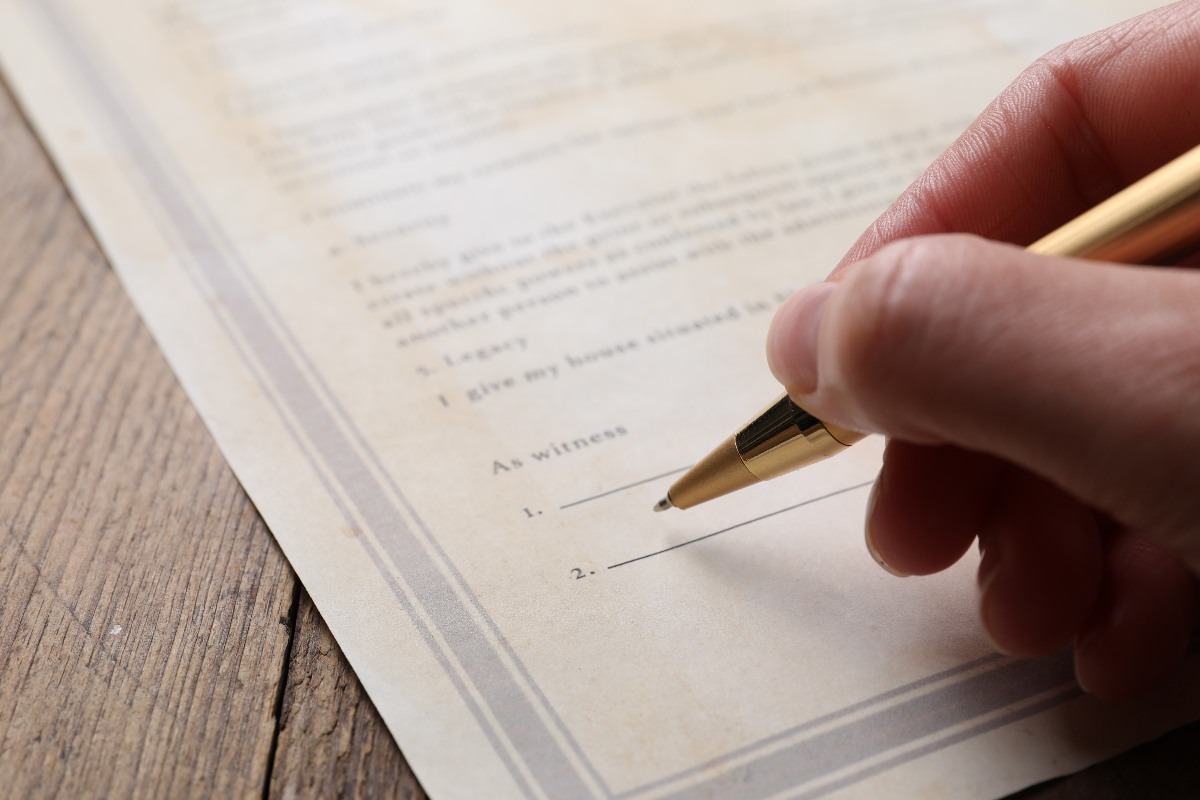 una mano che firma con una penna un documento
