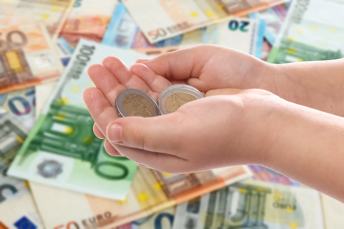 mani di una donna che mantengono delle monete e dei risparmi
