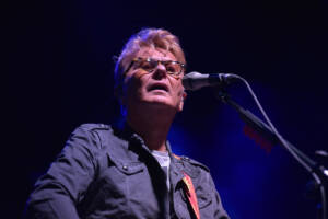 il cantante Ron si esibisce sul palco con microfono e chitarra