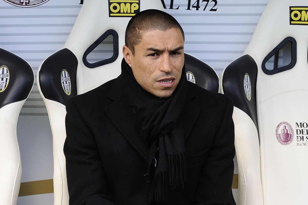 l'ex difensire Ivan Ramiro Cordoba seduto su una panchina di un campo da calcio a Siena