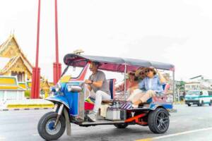 un tuk-tuk con a bordo alcune persone in strada