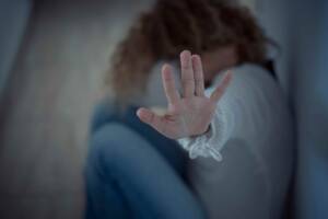 una donna che con la mano chiede di fermare atti di violenza nei suoi confronti