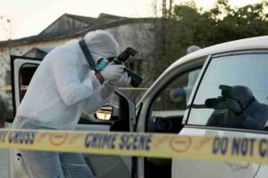 agenti della scientifica che analizzando una scena del crimine scattando delle foto dentro un'auto