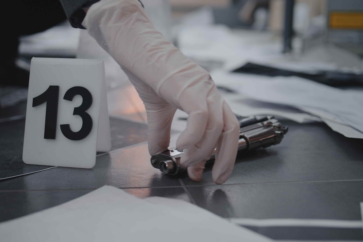 scientifica sulla scena del crimine con una pistola