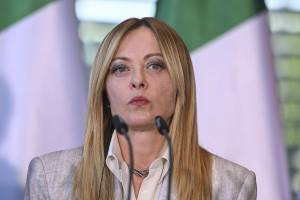 la premier italiana Giorgia Meloni parla con il microfono durante un vertice a Berlino
