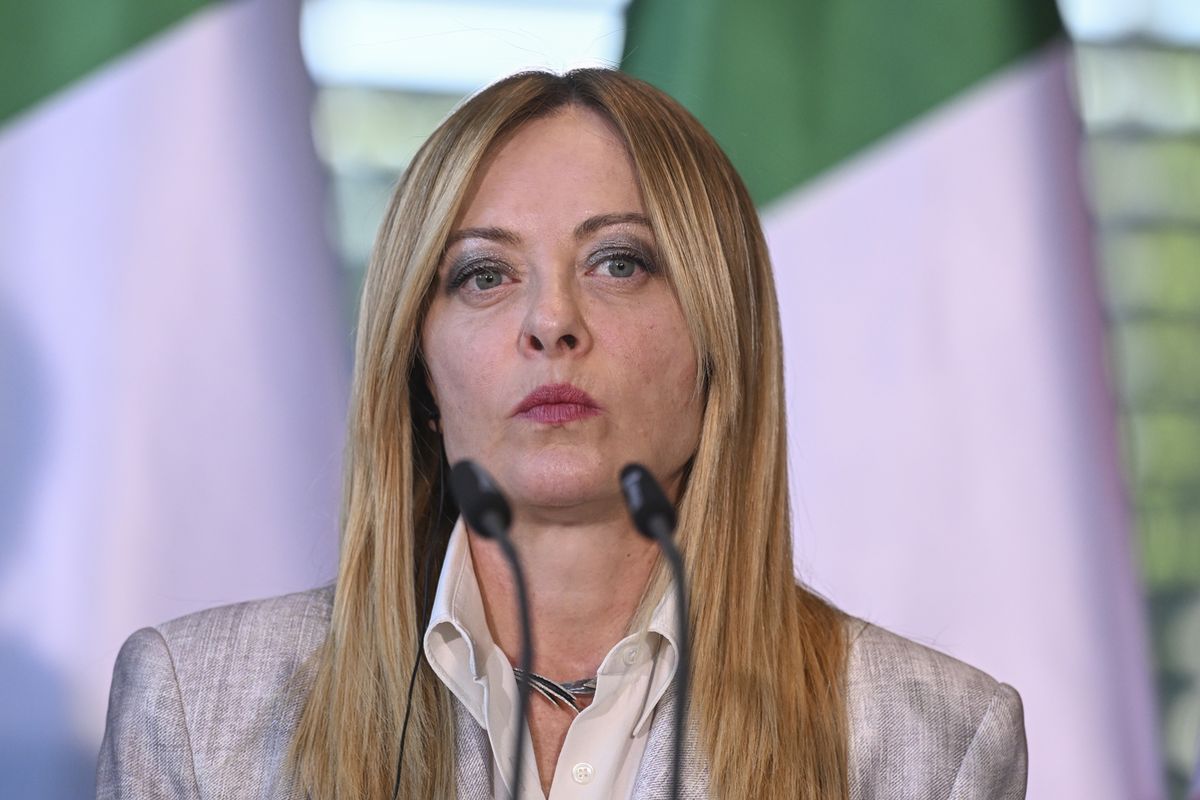 la premier italiana Giorgia Meloni parla con il microfono durante un vertice a Berlino