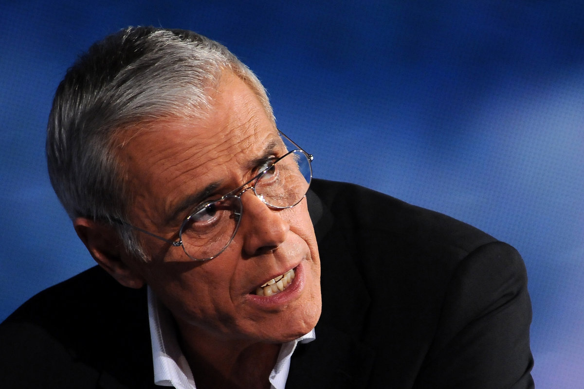 Teo Teocoli con lo sguardo rivolto verso qualcuno e gli occhiali da vista